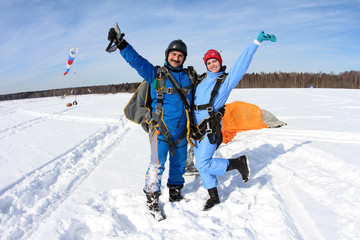 Girl and tandem instructor are smiling after tandem jump.