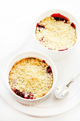 Cherry crumble in a white form on a white background. Food concept