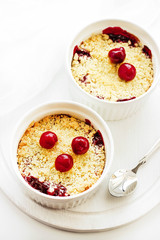 Cherry crumble in a white form on a white background. Food concept