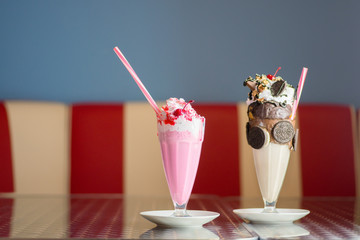 Milkshakes on the table (focus on the cherry milkshake) - obrazy, fototapety, plakaty