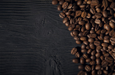 coffee beans on a black old  wooden bg top view