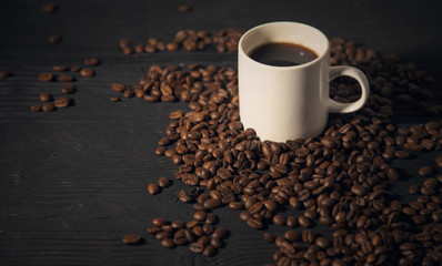 coffee beans white cup  on a black old  wooden bg  photo