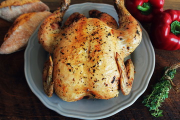 Whole roasted chicken on rustic table