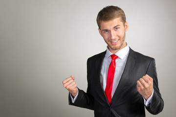 Successful young man celebrating with arms up
