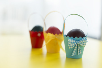 Colorful eastern eggs warped in paper cups. Selective focus