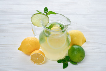 Citrus lemonade and lime water with lemon sliced , healthy and detox water drink in summer on white wooden table