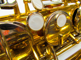 Obraz na płótnie Canvas Old golden saxophone close-up. Beautiful vintage shiny brass jazz musical instrument.