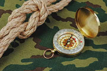 Compass and rope on a camouflage background