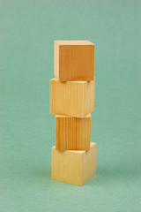 wooden geometric cube on a green background