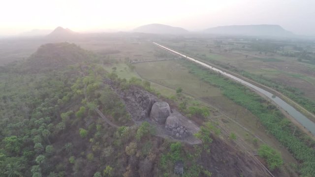Aerial view of an ancient fort in India with mountain and a sunset in the horizon.
