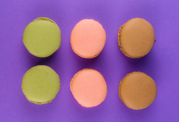 Sweet macarons on violet background