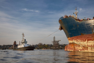 Schlepper zieht Containerschiff in Position