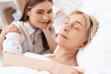 Obraz na płótnie Canvas Girl is nursing elderly woman at home. Woman is sleeping peacefully.