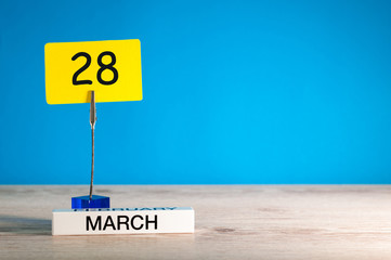 March 28th. Day 28 of march month, calendar on little tag at blue background. Spring time. Empty space for text, mockup