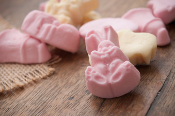 Obraz na płótnie Canvas closeup of easter candies in shaped bell and rabbit on wooden table background