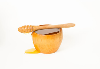 Honey in a wooden bowl and a honey dipper.