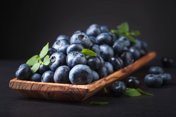 Blueberries in old wooden dish .