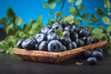 Blueberries in old wooden dish .
