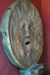 Tourist attraction carved stone human mask Bocca della Verita or pagan God indoors