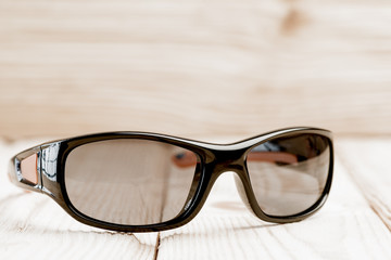 sunglasses lie on a wooden surface, photographed close-up