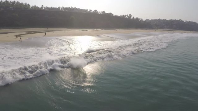 A gorgeous wave building to hit the shore of a tropical beach in Varkala located in Kerala, India.