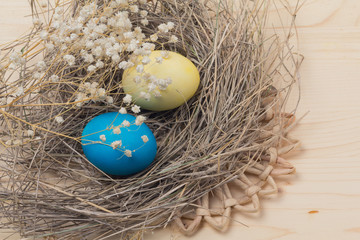 Easter eggs and nests on wooden surface
