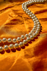 Pearl necklace on the orange cloth
