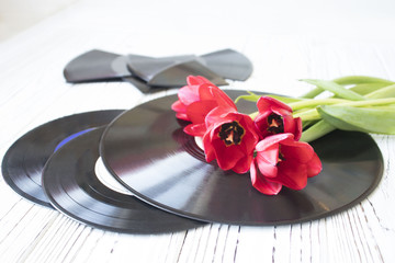 old music records and tulips on white wooden table