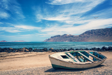 Fototapeta na wymiar Old colorful fishing boat, atlantic ocean in the background, Lanzarote, Canary islands, Spain