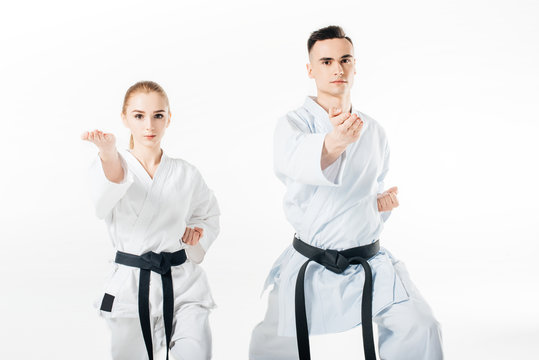 Karate fighters with black belts training isolated on white