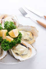 Opened oysters, ice and lemon on wooden board over stone table. Half dozen. With copy space