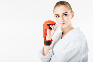 female karate fighter holding mouthguard and looking away isolated on white © LIGHTFIELD STUDIOS