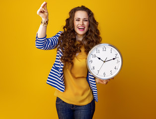happy woman on yellow background with clock snapping fingers