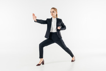 Fototapeta na wymiar businesswoman exercising karate in suit isolated on white