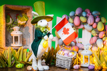 The Feast of Easter. Rabbit with colorful eggs. Feast of the Passover in Canada. Flag of Canada is holding an Easter bunny. Holidays in Canada