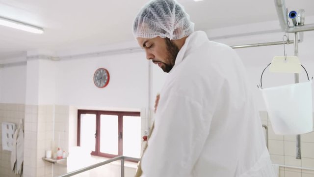 diary cheese factory Diary- operator mixing milk in the cauldron