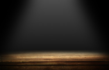 Wood table in dark room with light background.