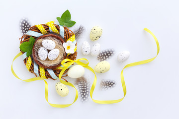 Easter eggs in the nest on a white background. Festive easter background. Top view