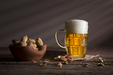 Bowl of peanuts and jug of light beer