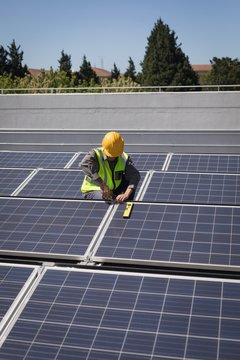 Male worker working on solar panels at solar station
