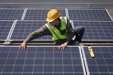 Male worker working on solar panels at solar station