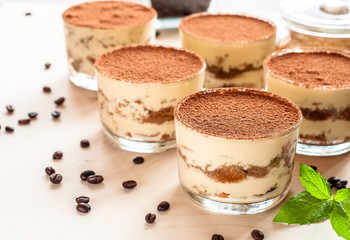 Homemade tiramisu, traditional Italian dessert in glass on wooden table