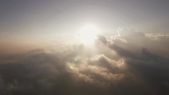 aerial shot of sunrise over the mountain with rain cloudy sky camera moving backward from the sun at the sky horizon