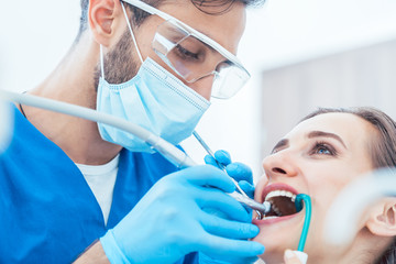 Zahnarzt behandelt Patientin in seiner Praxis