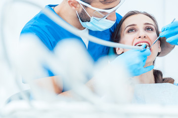 Zahnarzt behandelt Patientin in seiner Praxis