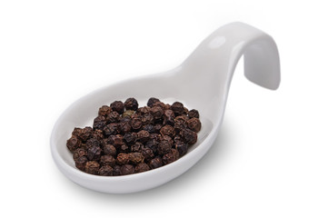 Black pepper in white spoon isolated. Spices.