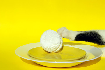 Fanny Animals, Pets, Cats Concept.Cat`s Paw,Plate, Marshmallow Over  Yellow Background.Cat And Dish.Cat Steals Food From Table, Cropped Shot.
