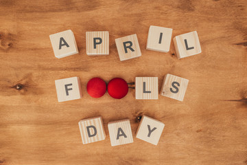 top view of arranged wooden cubes in april fools day lettering on wooden tabletop, 1 april holiday concept