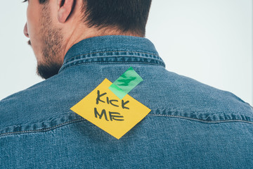 back view of man with note on sticky tape with kick me lettering on back, april fools day holiday...