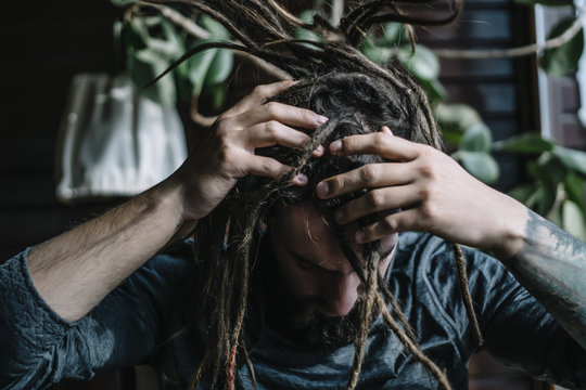 Close up of man shaking head with dreadlocks